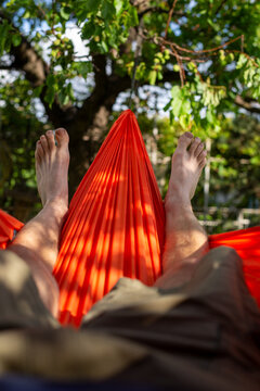 Relaxing in an Orange Hammock - Bare Feet in Backyard