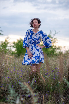 Woman in Blue Floral Dress Standing in Wildflower Field