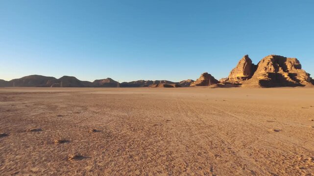 Driving in Wadi Rum at afternoon, car goes over sandy desert, sandstone sunlit mountains background distance, pov video