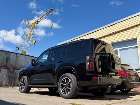 Black Haval H9 luxury off-road SUV wrapped in clear polyurethane anti-gravel film for paint protection, parked outdoors. Chinese premium 4x4 vehicle with glossy protective PPF wrap against chips. 