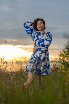 Woman in Blue Patterned Dress at Sunset