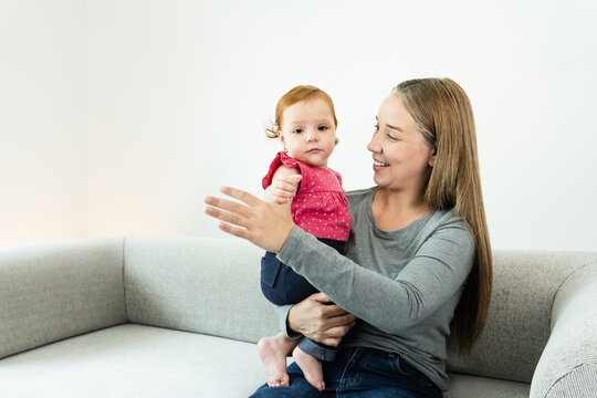 Happy Latin American mother and daughter hugging each other at home - Family love concept - Focus on child baby face - UGC content