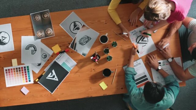 Top view of business people working together to choosing color from color palette. Project manager present idea by using tablet to marketing team while business man looking at logo graphic. Symposium.