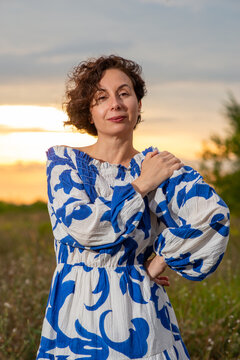 Woman in Blue and White Dress at Sunset