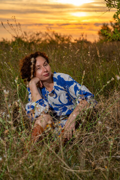 Woman Relaxing in Wildflower Field at Sunset