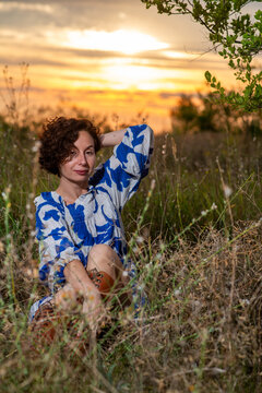 Woman Relaxing in Meadow at Sunset