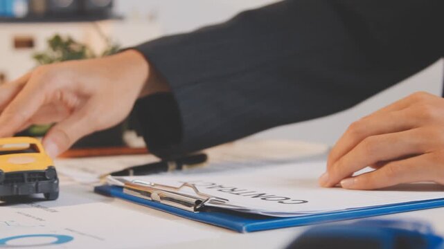 Car sale or rental concept, Closeup Dealership manager signing car insurance document or lease paper contract. Customer with car dealer agent making deal, sign on agreement document contract in office