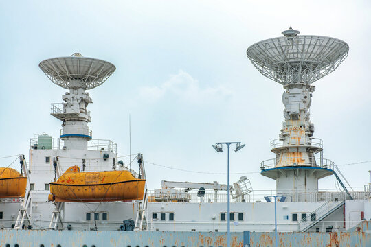 Large parabolic tracking antennas installed on specialized ship. Radar technology, satellite communication, telemetry, ocean surveillance and maritime monitoring concepts