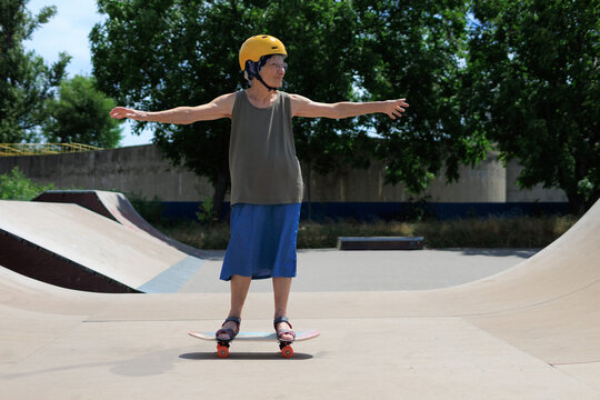 Elderly woman riding a skateboard in skatepark