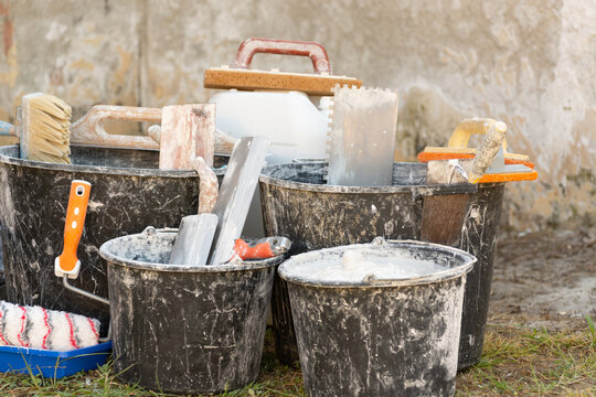 Home renovation with building materials, plaster, paint, and tools for interior construction and finishing work. Concept: providing construction, repair, and finishing services.