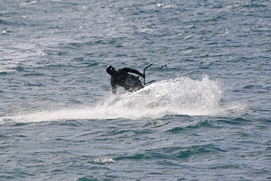 	
kitesurfer riding his board on the sea	