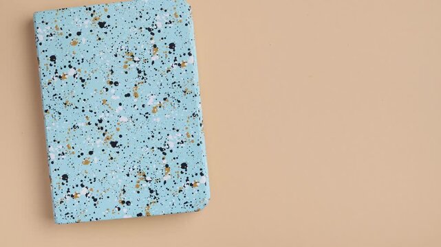 Stop motion animation transitioning from a flat lay of school supplies to an open grid notebook, where wooden letters appear one by one spelling "back to school", followed by wooden heart and star dec