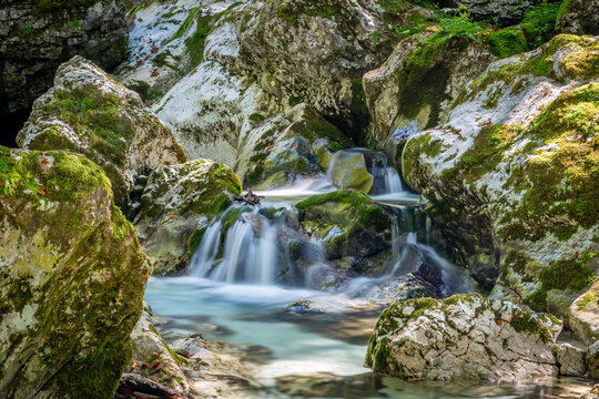 Clear waters flow gently over mossy rocks in Sunik, lepena Valley,, Slovenia, creating a peaceful natural retreat ideal for travelers seeking tranquility.