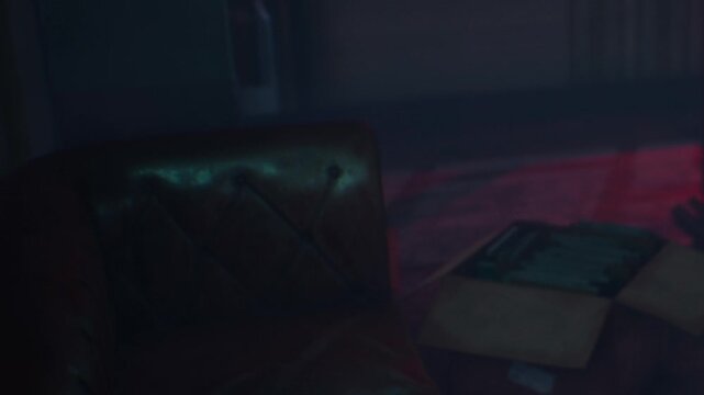 A room is dimly lit with a leather couch situated against the wall. A box is placed on the floor nearby. The setting is quiet and has an atmosphere filled with shadows.