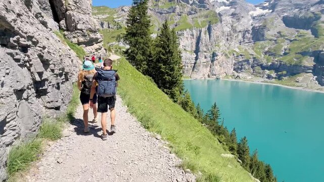 Oeschinen Lake, Switzerland - August 14, 2026: Tourists hiking along the lake with views of the Swiss Alps