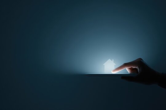 hand holding tablet displaying glowing digital house icon representing smart home innovation