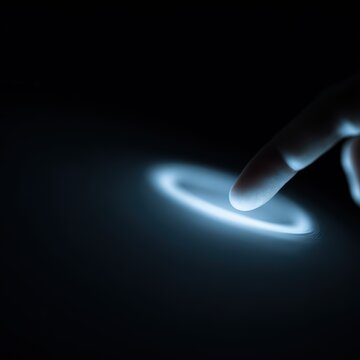 finger touching glowing blue circular interface on dark background futuristic technology interaction