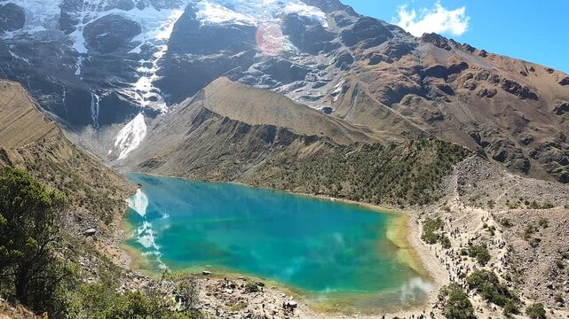 Hiker trekking through the Andes with mountain and Humantay Lake views near Machu Picchu, Peru