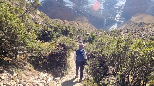 Hiker trekking through the Andes with mountain and Humantay Lake views near Machu Picchu, Peru