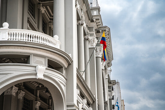 Historic Municipal Palace of Guayaquil overlooking Plaza de la Administraci&oacute;n in Ecuador, featuring an ornate neoclassical facade, monumental columns, domes and a prominent historic monument in the fo