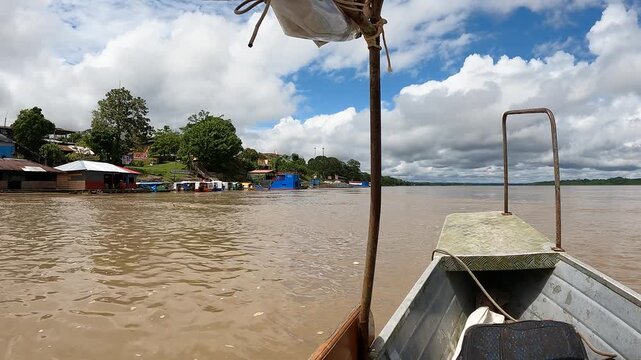 Small motorboat with two men navigating the Amazon River through the rainforest