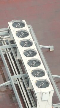 Long white HVAC unit with six circular fans mounted on grey steel frame. Top down architectural perspective. Symmetrical industrial engineering layout with geometric precision. high quality 4k video.