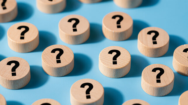 Wooden blocks with question mark symbols on blue surface. Business support and FAQ theme.
