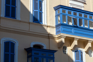 Bright blue gallarija balconies and shuttered windows stand out against a cream-coloured facade in Valletta, Malta © Tony Blood