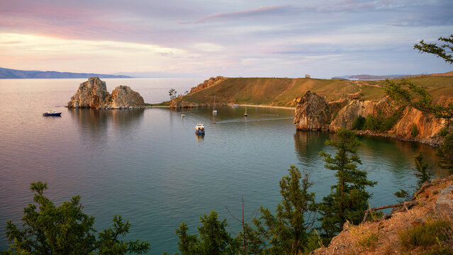 Shamanka Rock on Olkhon Island at Lake Baikal. Scenic sunset landscape of Cape Burkhan in Siberia Russia. Famous natural landmark and travel destination