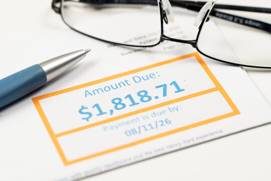 A utility bill displaying the amount due and payment deadline with a pen, illustrating household expenses, budgeting, medical bill payments, personal finance and financial planning.