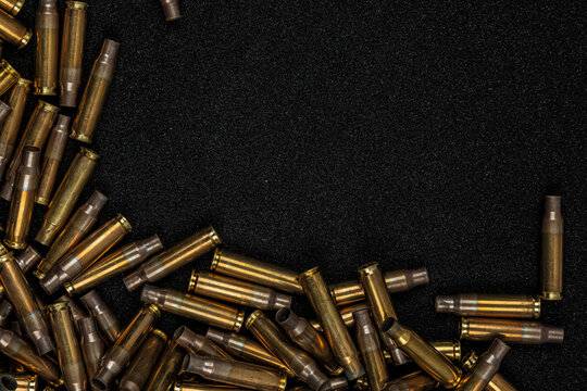 Empty brass bullet casings lying on dark grey foam background