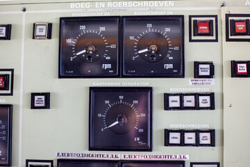  Ship engine room control panel with RPM gauges and labeled switches, showing the technical instruments used to operate a working vessel © Татьяна Швец