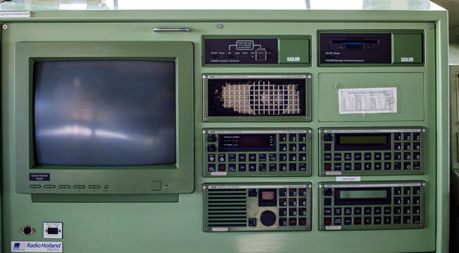 Varna. Bulgaria. 09.08.2026 Vintage green radio navigation console with a screen and keypads on a ship's bridge, showing old maritime communication technology