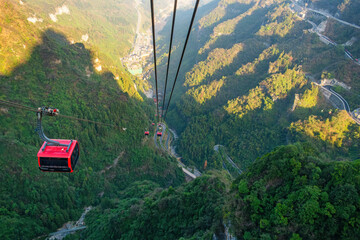 Cable car gondola crossing steep forested valley at Tianmen Mountain near Zhangjiajie, Hunan, China. Mountain transport and panoramic scenery represent tourism, engineering, accessibility © samael334