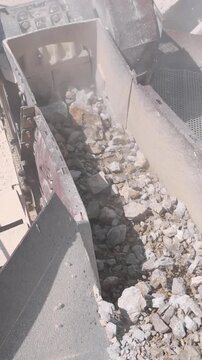 Stone crushing machine at open pit mining and processing plant for crushed stone. Loading of stone into the crusher and conveyor belts. Concepts of industry and building materials, sand and gravel
