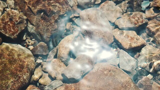Cool summer river water flowing over rocks in slow motion