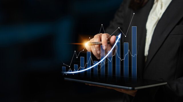 A business professional demonstrates growth and success using a digital tablet featuring an upward-trending graph, symbolizing performance and strategic planning. Scalp