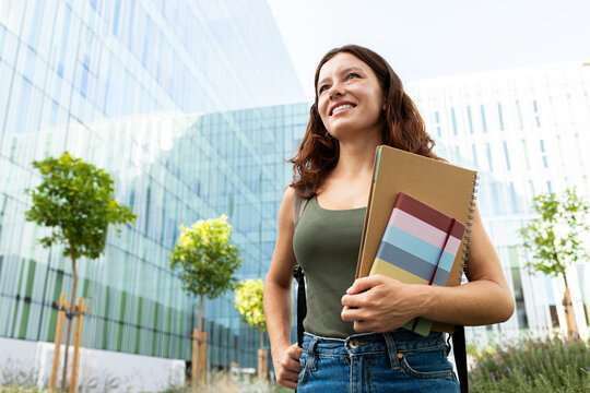 Young woman student walking on urban university campus