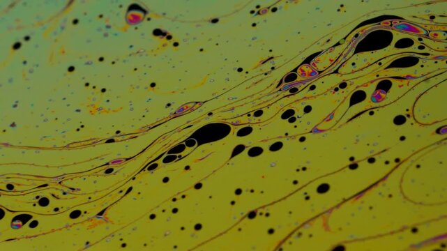 Abstract Macro Fluid Dynamics with Swirling Black Droplets and Iridescent Trails on Yellow Background