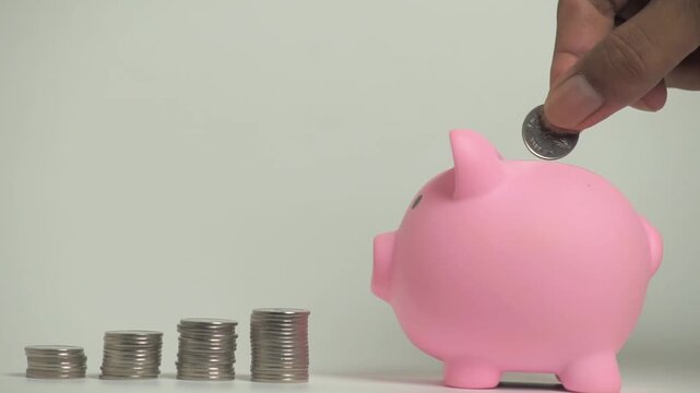 Save money and account banking for finance concept, Hand with coin and piggy bank on blurred background