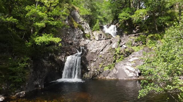 Aerial Ascent of Eas Chia-aig, the Witches Falls, rising above the Treetops, Lochaber, Scotland
