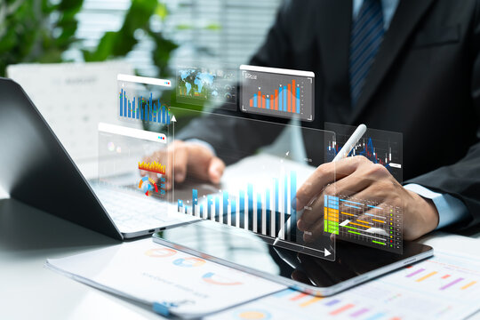 Businessman reviews financial data analytics with digital charts and dashboards on laptop and tablet, representing market research, investment strategy, performance tracking, and business growth.