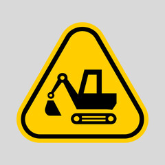 Yellow triangular warning sign featuring a construction excavator, indicating machinery operation and workplace hazard. © Umm Hamzah