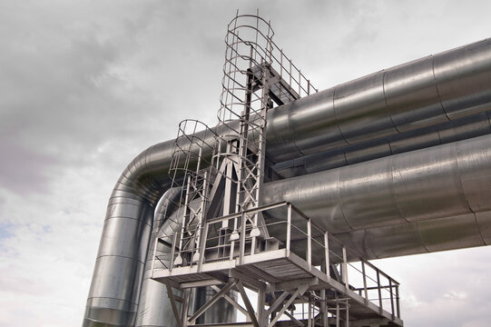 a pipeline on a metal support against a gray sky