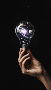 Hand holding a glowing planet inside a light bulb
