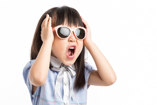 Furious little girl screaming loudly with hands up, concept of losing control and anger.