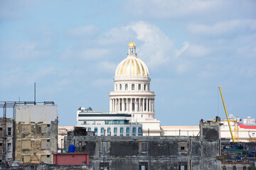 Fototapeta premium All white Capitol building in Havana, Cuba in distance beyond city structures and a blue sky