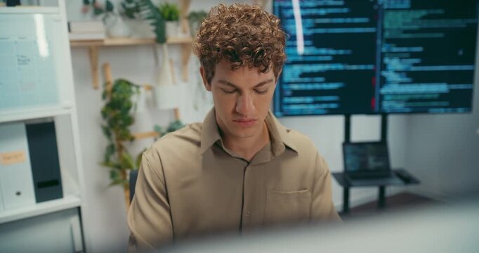 Young Caucasian male programmer working on coding in startup office workspace. Software developer artificial intelligence engineer technology, computer network digital system server security concept.