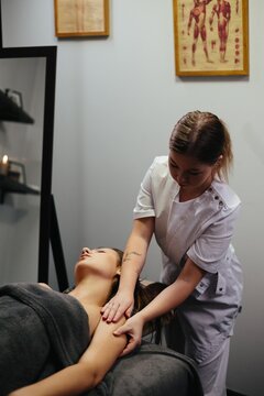 Woman masseuse giving professional shoulder massage