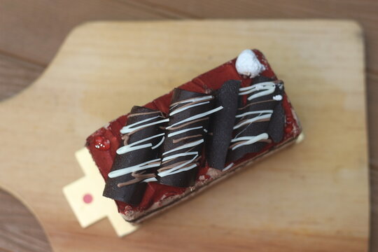 Decorative Chocolate Cake Slice on Wooden Board